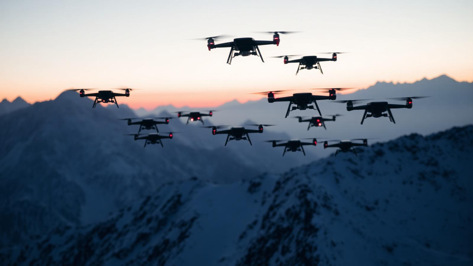 Coordinated drone swarm flying over a snow-dusted mountain ridgeline at dusk